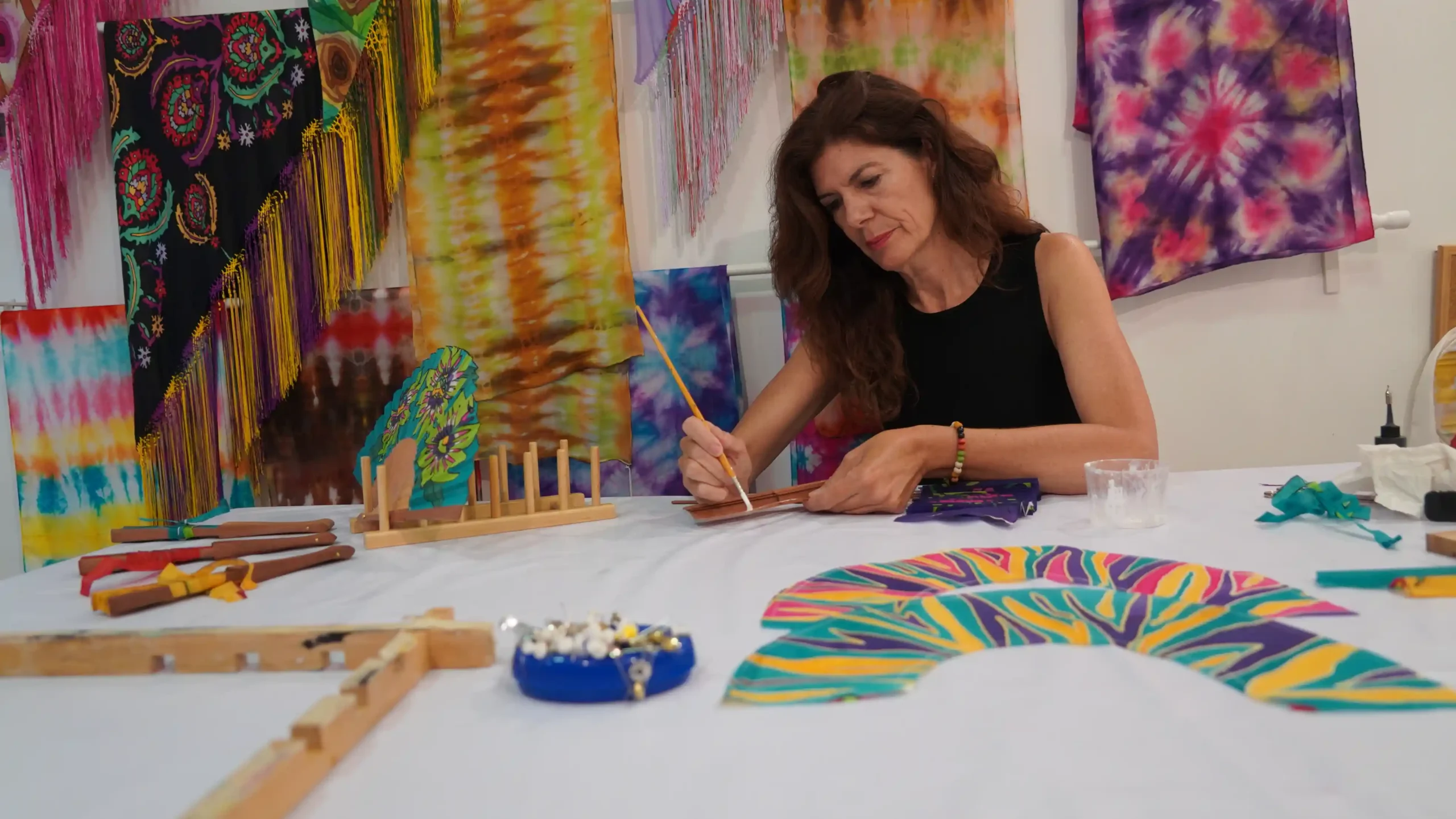 Silvia Ramos, artesana, pintando abanicos personalizados en seda natural.