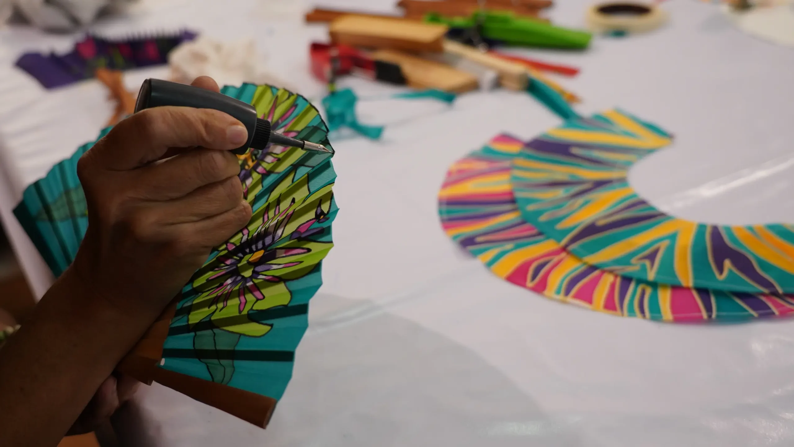 Crafting a handcrafted natural silk fan at Manos de Agua.